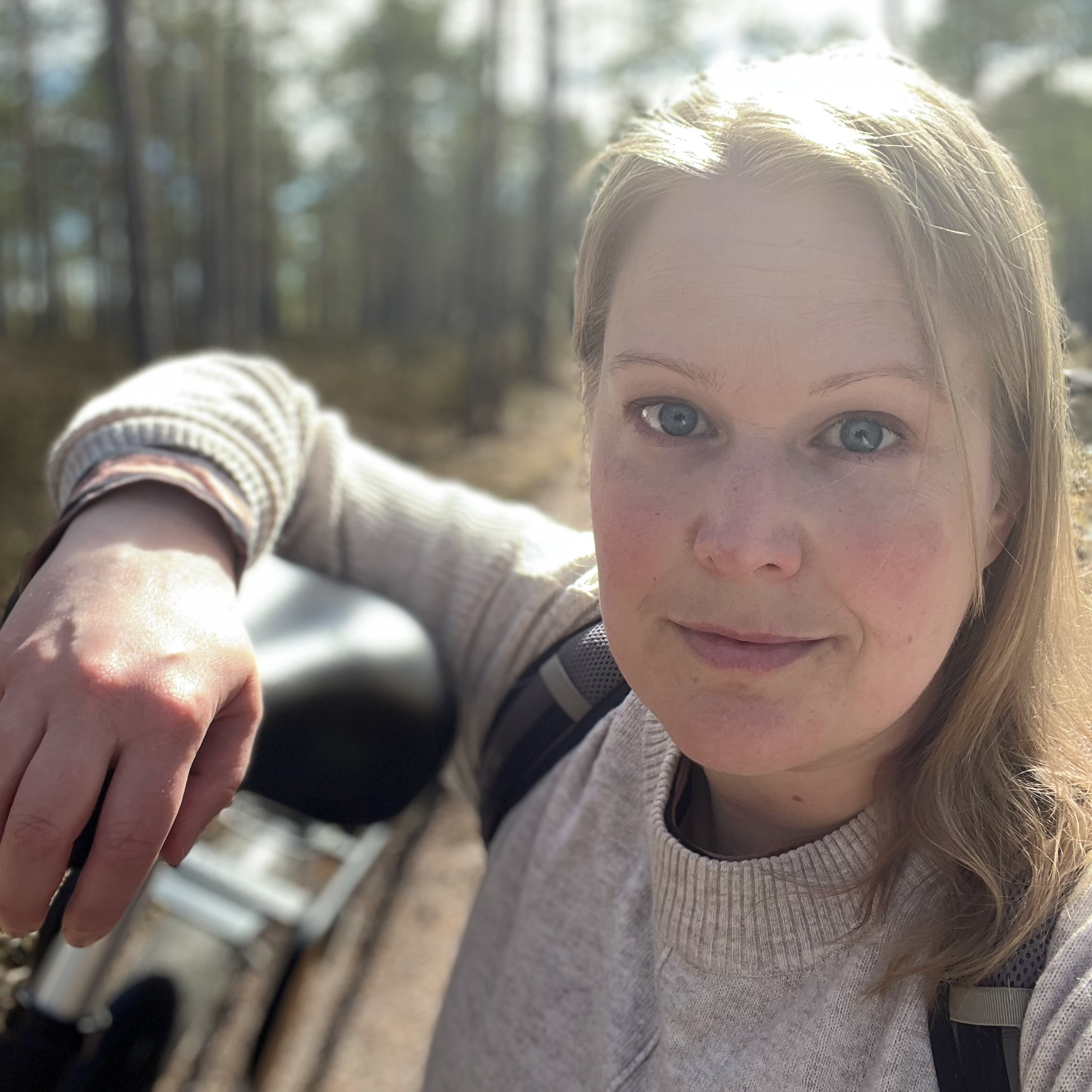 Portrait of Sofia Lindstöm with a bike and trees in the background.